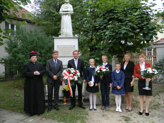Kwiaty pod pomnikiem św. Maksymiliana Marii Kolbe w Śliwicach